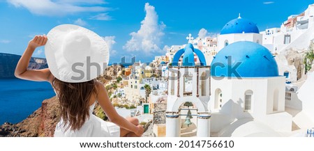 Travel vacation europe summer holidays tourist woman looking at Greek Santorini famous attraction wearing white hat. Banner panoramic landscape.
