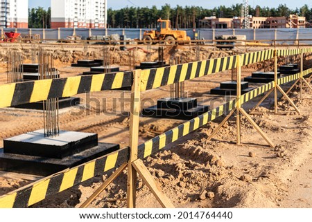 Construction pit fencing. Construction safety. Construction site with reinforced concrete foundations with protective fencing