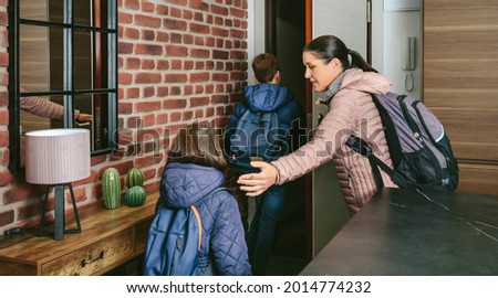 Family with emergency backpacks leaving their front door quickly due to an emergency evacuation Royalty-Free Stock Photo #2014774232