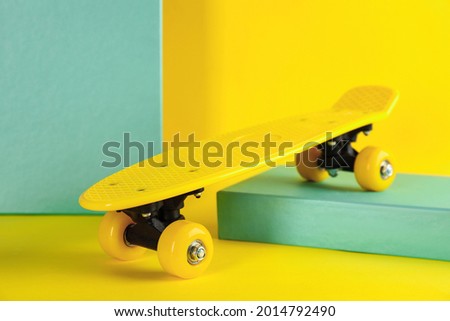 Yellow skateboard on color background. Sport equipment