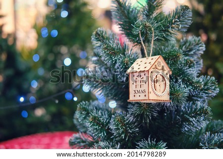 A toy on the Christmas tree in the form of a wooden house
