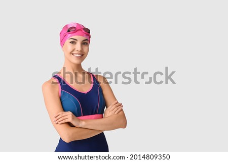 Female swimmer on light background Royalty-Free Stock Photo #2014809350