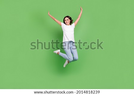 Full size photo of cool brunette millennial lady jump wear t-shirt jeans isolated on green color background