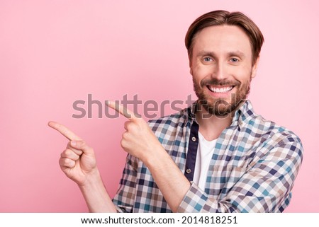 Photo of young man happy positive smile indicate fingers empty space subscribe recommend advise isolated over pink color background