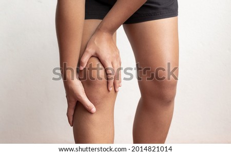 A woman supporting herself from numbness, muscle weakness, pain, and tingling in the knee nerve endings. This is a side effect of Guillain-Barre Syndrome after vaccination against COVID-19.