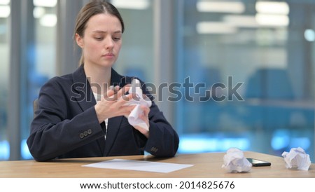 Young Businesswoman Trying to Write on Paper in Office