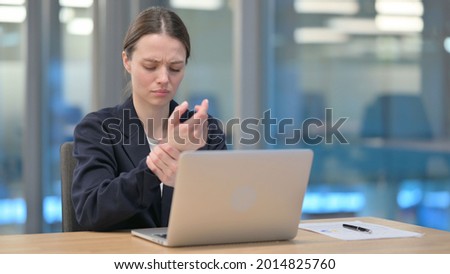 Young Businesswoman having Wrist Pain while Typing on Laptop