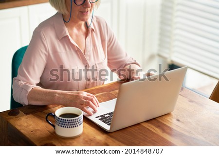 Close up of senior woman using laptop at home                               