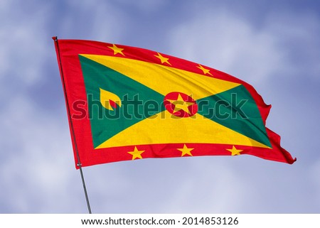 Grenada flag isolated on sky background. National symbol of Grenada. Close up waving flag with clipping path.