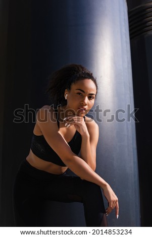 African american sportswoman in earphone looking at camera outdoors at daytime