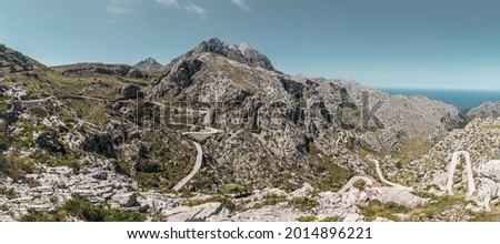Panoramic shot of the majestic viewpoint looking down at the mountain road of Coll dels Reis that twists and turns down towards the sea on Mallorca
