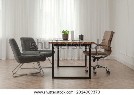 Director's office with large wooden table and comfortable armchairs. Interior design Royalty-Free Stock Photo #2014909370