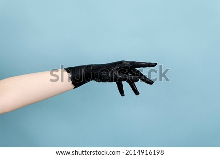 Photo of woman's hand with black acrylic paint on one hand