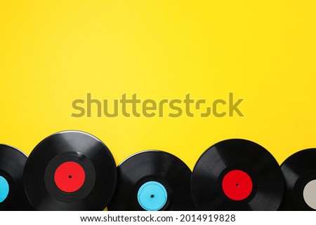 Vintage vinyl records on yellow background, flat lay