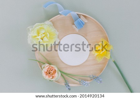 Fresh flowers and white round paper mock up. Flat lay, top view floral festive holiday concept.