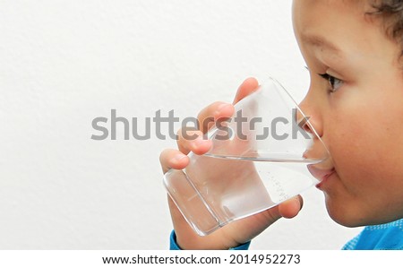 boy drinking water from a glass with white background stock photo