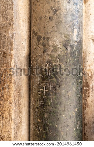 Religious crosses are carved on a stone column at the entrance to the Church of the Holy Sepulcher in Christian quarters in the old city of Jerusalem, Israel