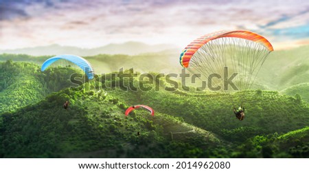 Paragliding multicolor. Paraglider flying over Landscape from the background Beauty nature mountain landscape of the sky. Paragliding Sports. Concept of extreme sport, taking adventure challenge. Royalty-Free Stock Photo #2014962080