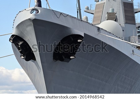 The bow of a warship. Black anchors stick out from both sides. The mooring rope stretches towards the shore. Royalty-Free Stock Photo #2014968542