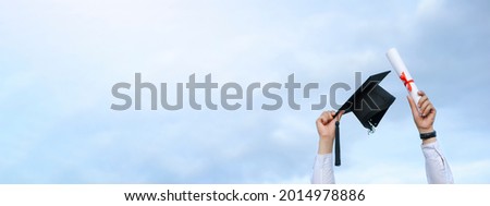 Graduates are celebrating graduation put a hand up, a certificate, and a hat in hand with happiness feeling in Commencement day, Congratulation, Graduation day concept  Royalty-Free Stock Photo #2014978886