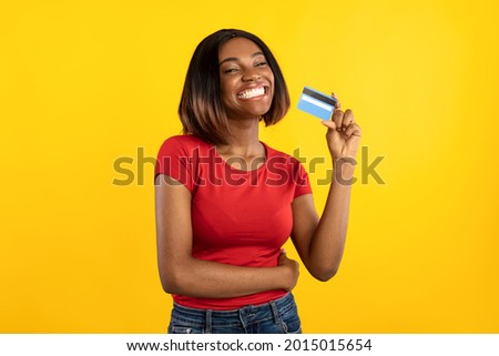 Happy African American Lady Holding Credit Card Advertising Bank Service Posing In Studio On Yellow Background, Smiling To Camera. Easy Banking, Money And Payment Concept Royalty-Free Stock Photo #2015015654