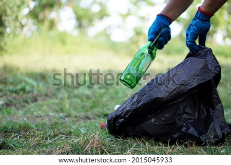 Concept : Environment conservation.                            Volunteer pick up beer bottle garbage that other people threw away and left in the park.  Cleaning public place activity. Recycle waste.  Royalty-Free Stock Photo #2015045933