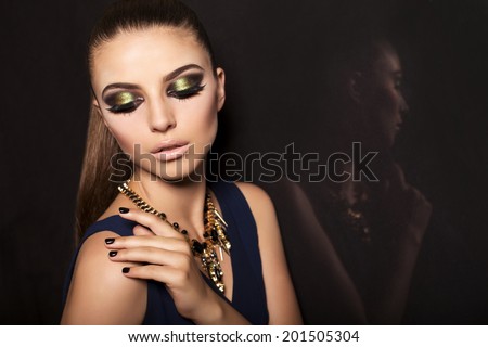 studio fashion photo of beautiful glamour model with dark hair with smokey eyes makeup and accessories