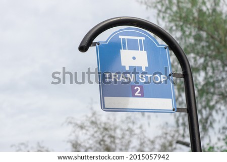 Tram stop sign on blue board at the roadside in the city