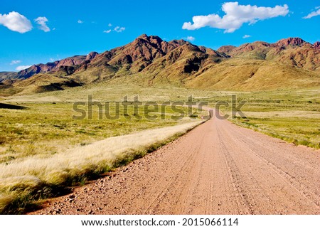 Sandy road leading to Mountains in Namibia, Southern Africa Royalty-Free Stock Photo #2015066114