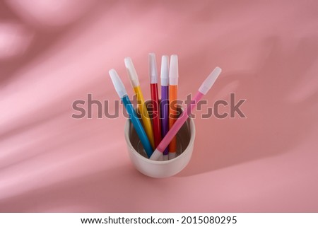 Colorful markers on a pink background