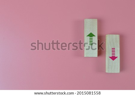 Wooden block with pink and green arrow symbols. Copy space