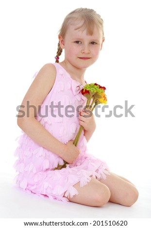 Girl in pink dress sits with a bouquet.happy childhood,sweet child having fun outdoor,playing isolated on white background, happiness concept,adorable child having fun in studio