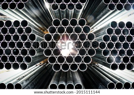 Construction tubes arranged in patterns in a warehouse. Industrial photography. Royalty-Free Stock Photo #2015111144