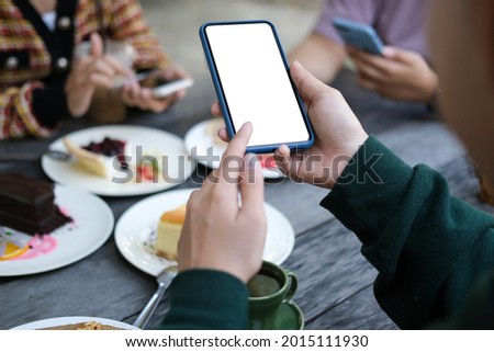 Young woman taking a photo of sweet dessert with smart phone.