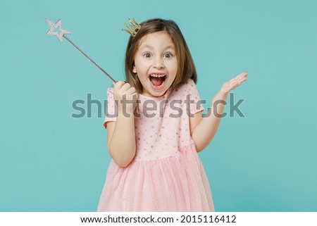 Little fun kid girl princess 5-6 years old wears pink dress crown diadem hold magic wand fairy stick isolated on pastel blue color background child studio. Mother's Day love family lifestyle concept