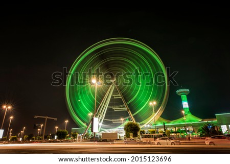 Long exposure photography of a giant wheel while rotating with colorful lights at the night time at UAE
