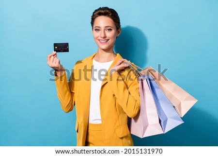 Photo of young woman happy positive smile hold credit card sale shopping isolated over blue color background