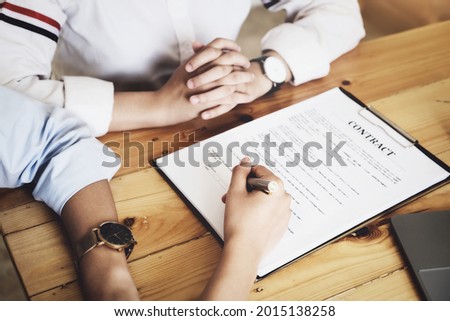 Business owner holding a pen to read the conditions to enter into a joint venture contract with a partner company.