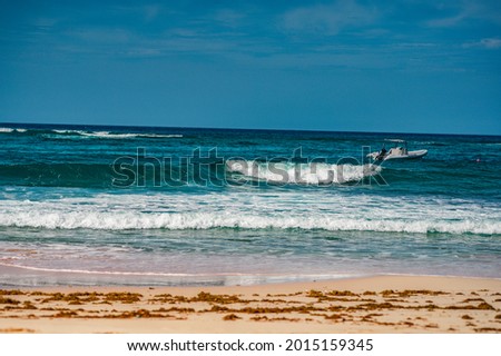 Photo of a sandy beach in the foreground from the Dominican Republic. The picture clearly shows the magnificent sand from the Atlantic Ocean and the bright blue sky, forming a horizon line.
