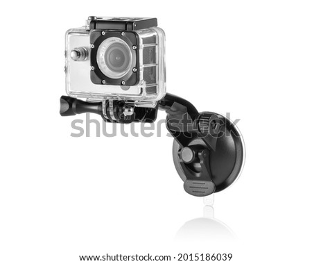 Silver action camera inside a waterproof box attached to a suction holder on white background with reflection underneath