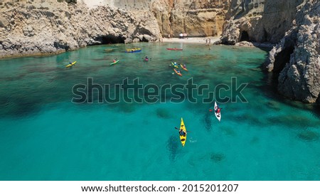 Aerial drone photo of women team of sport kayak in iconic beach and small cove of Tsigrado, Milos island, Cyclades, Greece