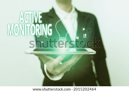 Text caption presenting Active Monitoring. Concept meaning person incharge go out and check workplace conditions Lady In Suit Presenting Mobile Device With Futuristic Interface Tech.