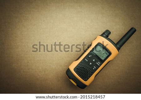Yellow walkie-talkie on a cardboard isolate, a place for text, search for missing persons