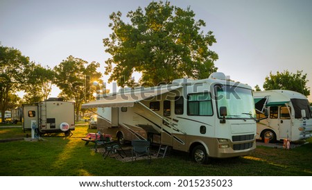 Sun going down at the Rv park with lights on the motor home  Royalty-Free Stock Photo #2015235023
