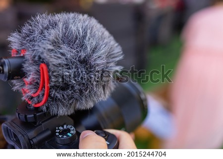 Production movie video concept : Professional videographer or photographer holding setting mirrorless camera shooting take photo or video for recording at outdoor.