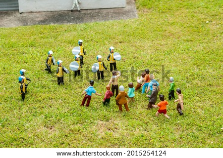 Closeup photo of tiny model riot police and protesters having a confrontation