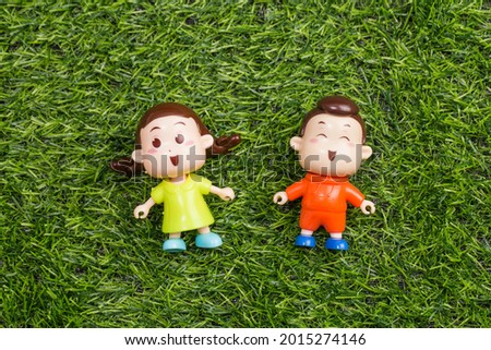 Dolls in the shape of a boy and a girl on the grass