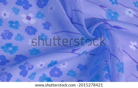 silk fabric, small flowers on a lilac background, a thin strip of azure tone with a print. Floral design. Background texture