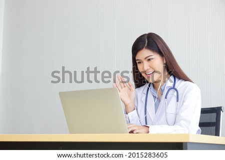 Asian female doctor online video call Check the symptoms with the patient via the Internet. on a laptop computer. The concept is connected to communication through online technology. Copy space