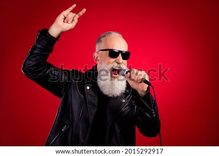 Photo of aged handsome man show rock sign sing song microphone concert hipster isolated over red color background